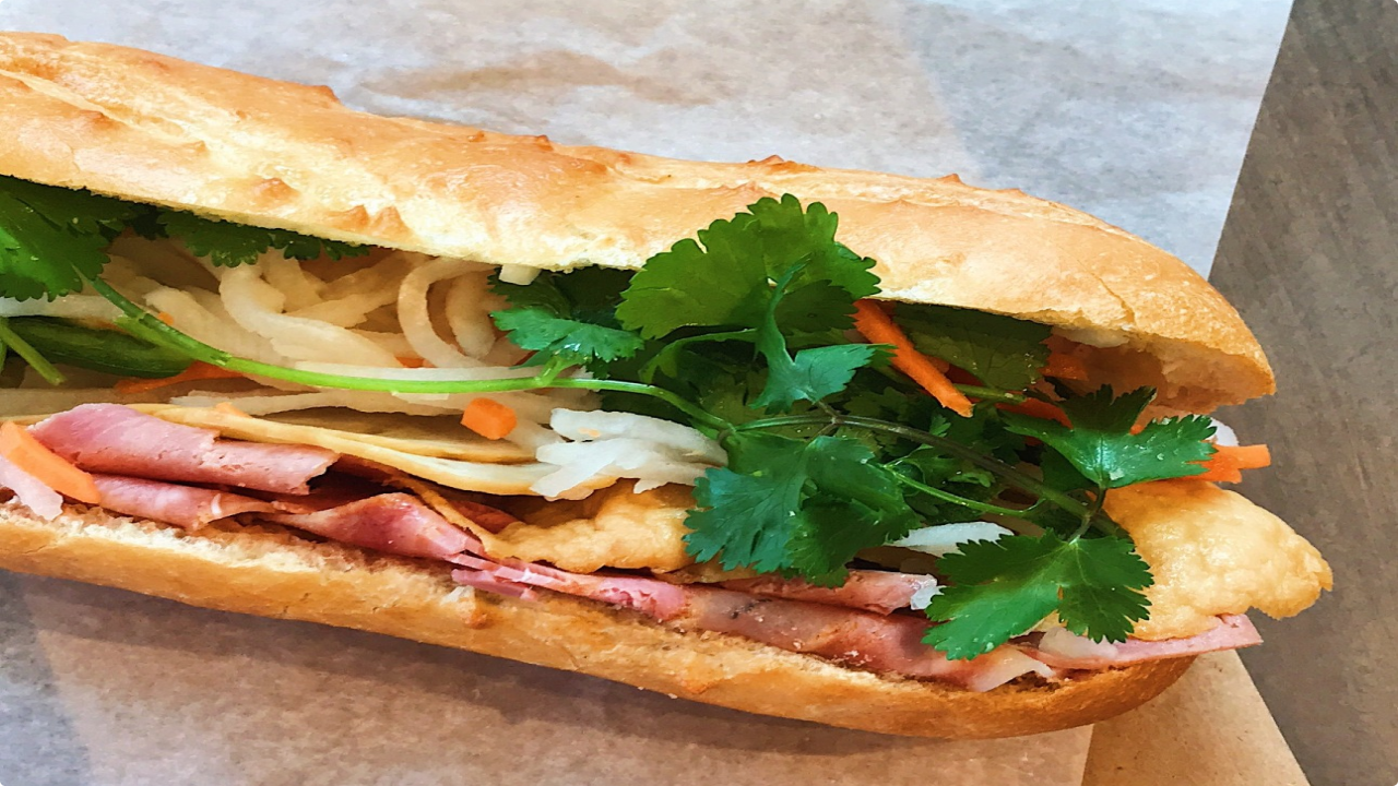 An image of Banh mi with filled meat, carrot pickled, and vegetables