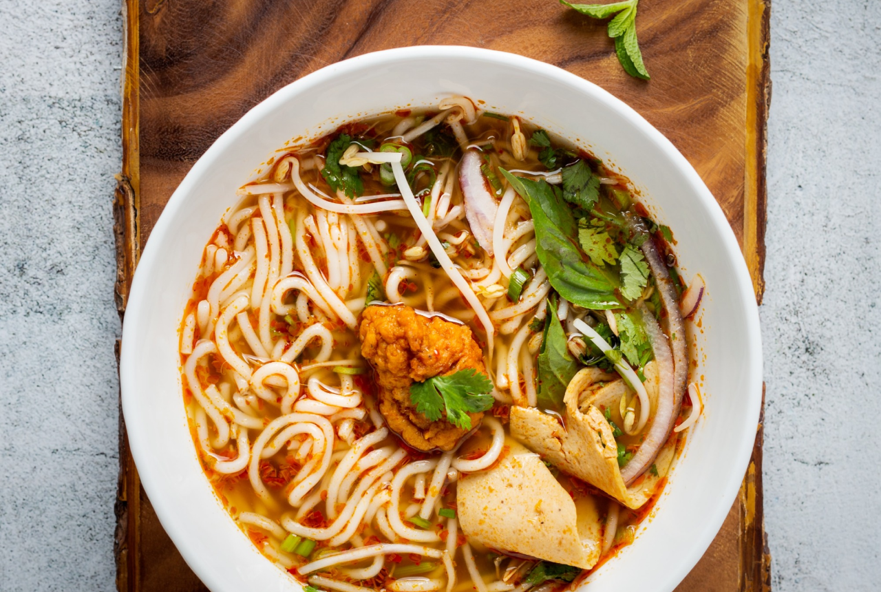 A bowl of bun bo hue, a vietnamese famous Beef Noodles from Huế on a table